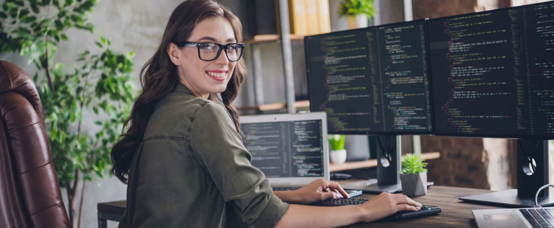 Ein Bild dass eine Frau zeigt, die vor einem Computer arbeitet, der zu einem Netzwerk eines KRITIS (Kritische Infrastruktur) Unternehmen gehört